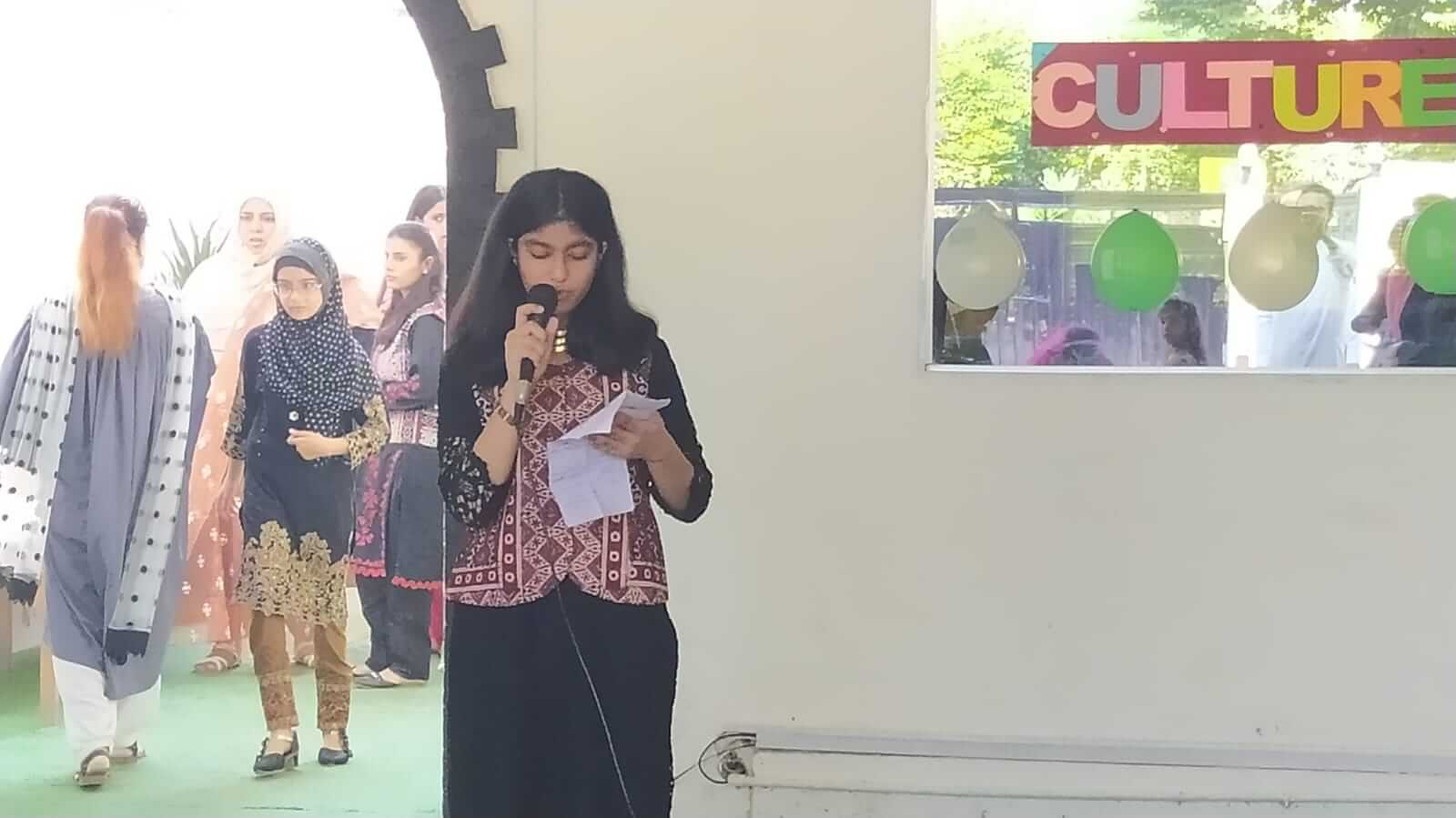 A senior section student speaking at an assembly